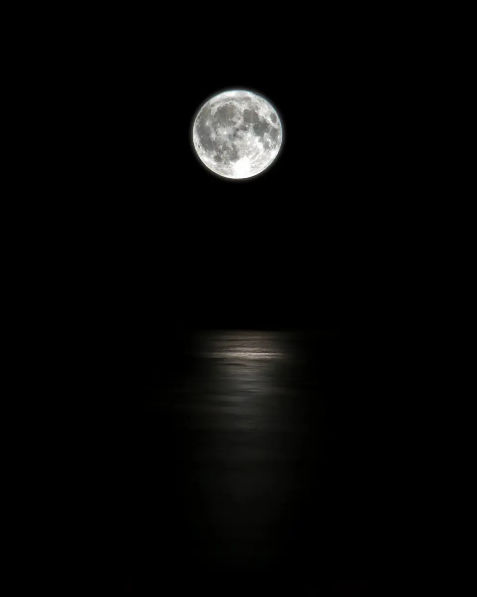 The moon low over open water